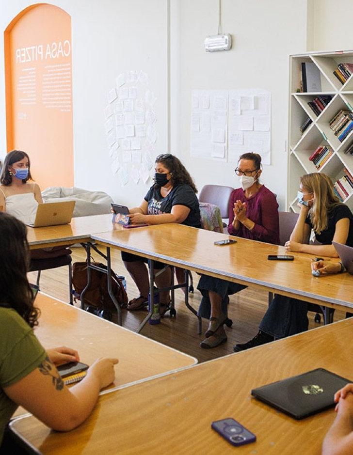 People sit around a u-shaped table at CASA Pitzer